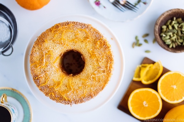 Orange Chiffon Cake on top of the cake stand. Chiffon cake has a hint of cardamom and powder sugar dusted on top.