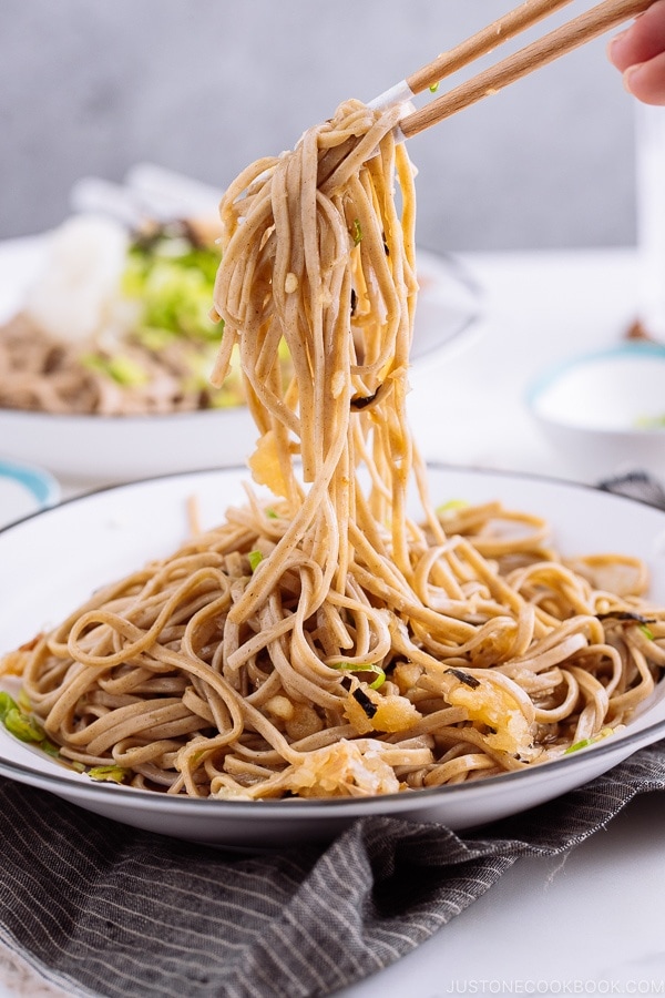 Oroshi soba noodles being picked up with chopsticks.