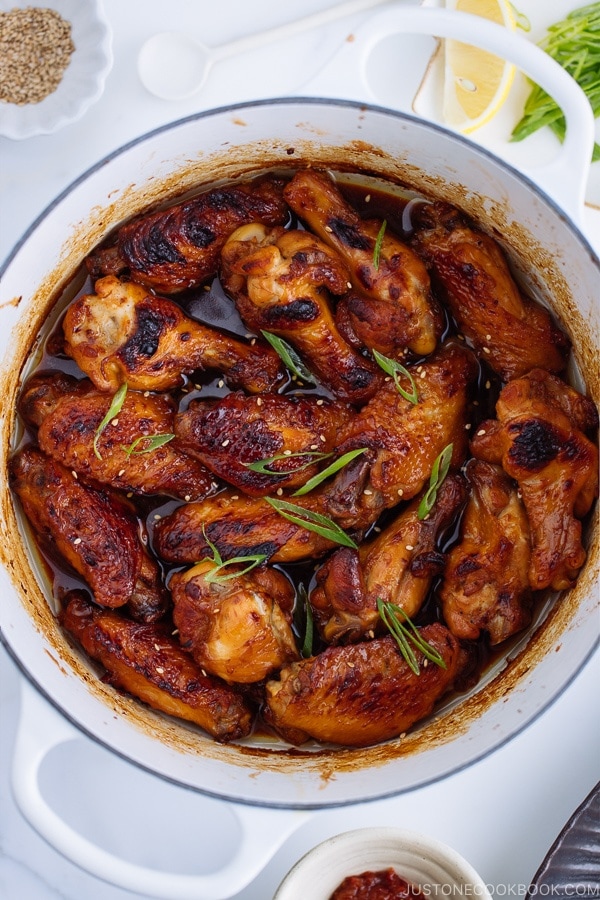 Teriyaki wings in a white Le Creuset pot.