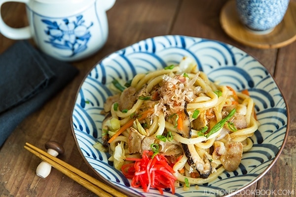 Yaki Udon with red ginger pickles on a plate.