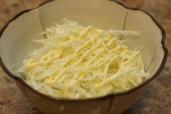mayo on top of cabbage slices in a bowl