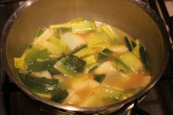 potato and leek pieces with water in a pan on the stovetop