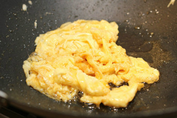 eggs almost done cooking inside a wok