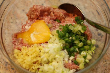 ingredients for homemade meatballs in a glass bowl on the countertop