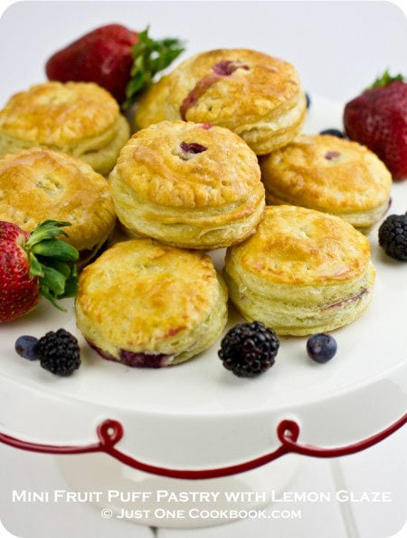 Mini Fruit Puff Pastry with Lemon Glaze and berries on a cake stand.