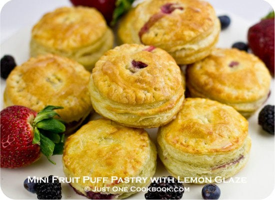 Mini Fruit Puff Pastry with Lemon Glaze and berries on a cake stand.