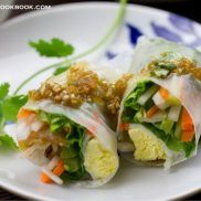 spring rolls wrapped in rice paper with sauce on top of white plate