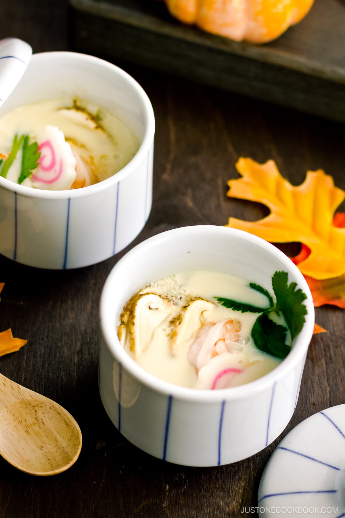 Chawanmushi cups containing matsutake mushrooms, shrimp, and fish cake slices in a savory steamed egg mixture.