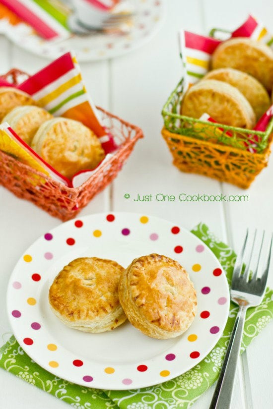 Tandoori Chicken Puffs on a plate and baskets on a table.