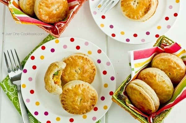 Tandoori Chicken Puffs on a plate and baskets on a table.