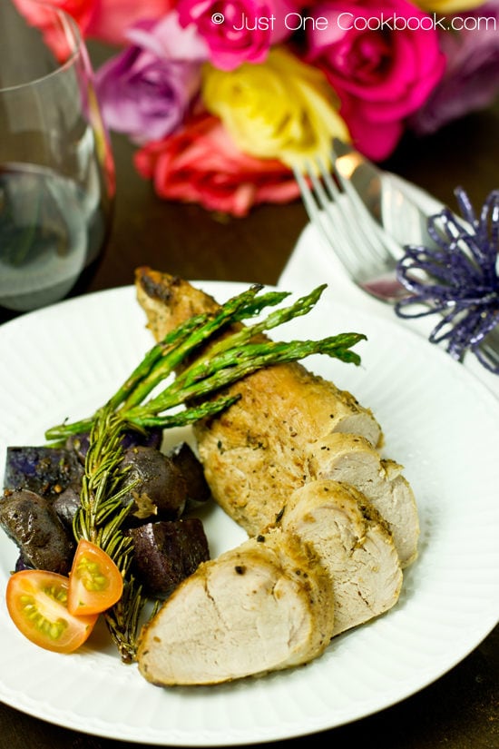 Thomas Keller's Brined Pork Tenderloin and potatoes and asparagus on a white plate.