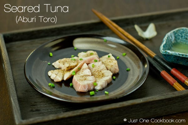 Seared Tuna Sashimi on a plate with green onion.