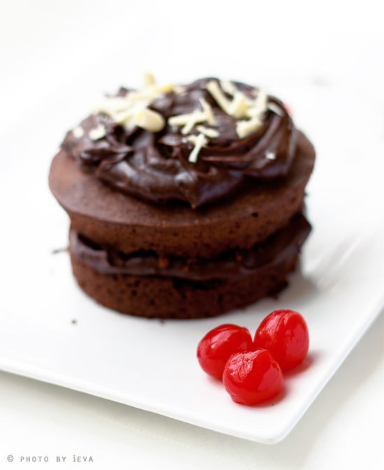 Chocolate Cake and cherries on a white plate.