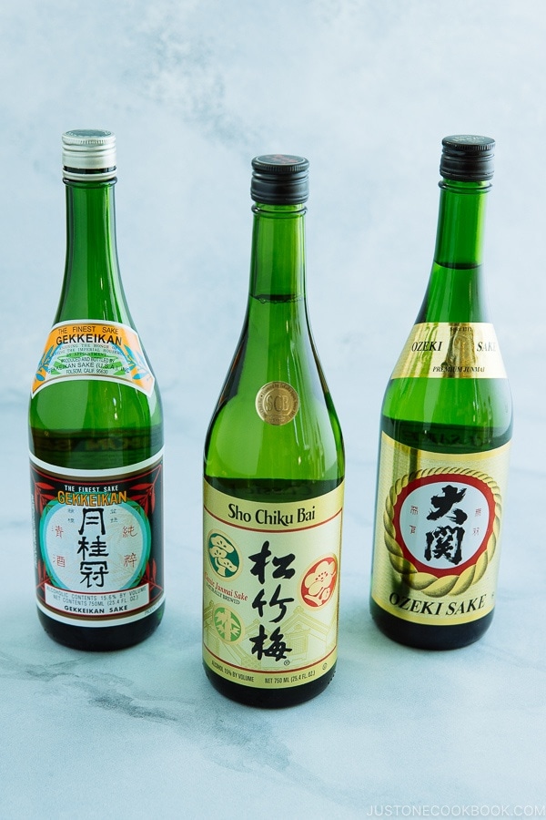 3 bottles of sake on top of white board 
