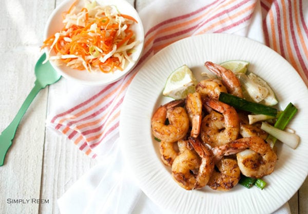 Honey Glazed Shrimps with Asian Coleslaw and Rose Cake in a white plate on top of white towel