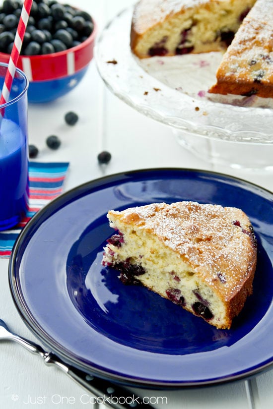 Blueberry Cake on a blue plate and a cake stand.