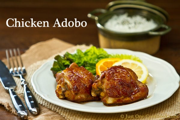 Chicken Adobo with green salad on a plate.