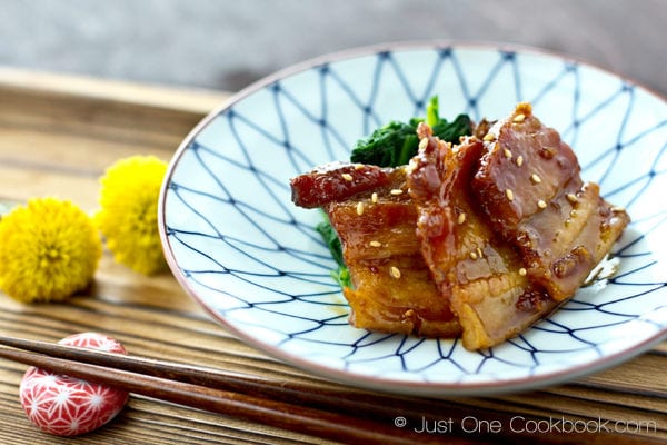 Honey Pork Belly and spinach on a plate.