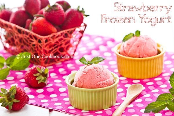 Strawberry Frozen Yogurt in cups and strawberry in a basket. 