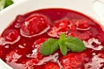 strawberry sauce with mint leaves in a white bowl