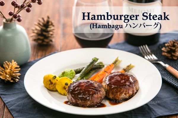 Hamburger Steak and grilled vegetable on a white plate and glass of wine.