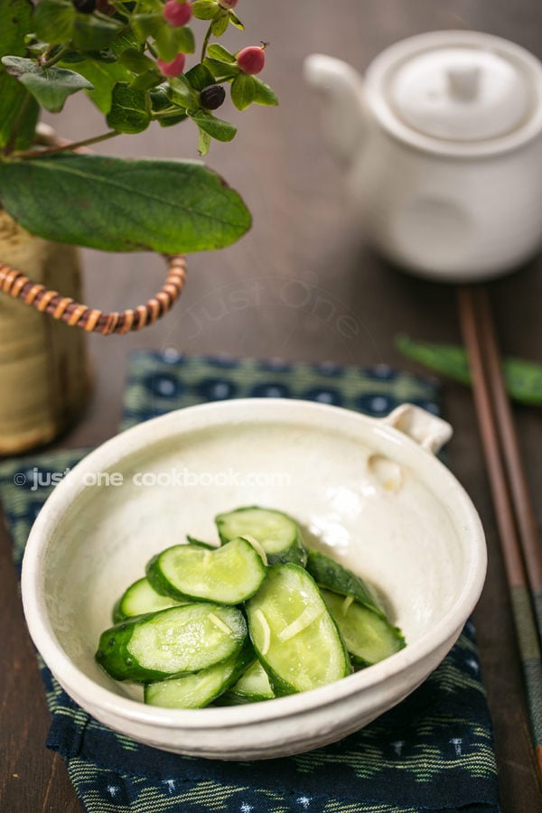 Pickled Cucumbers in a white bowl on a table.