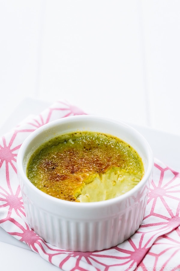 Green tea creme brulee in a white ramekin.