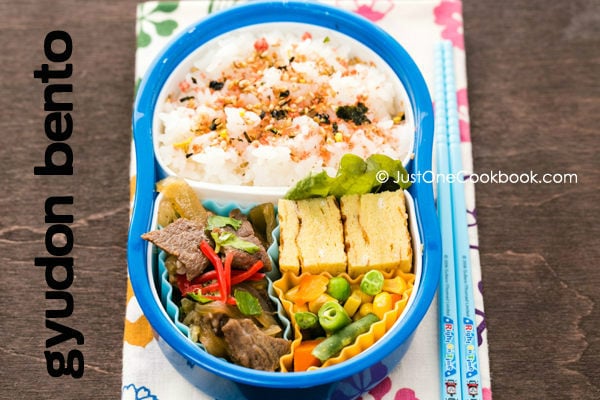 Gyudon Bento with eggs, furikake rice and mixed vegetables on a table.