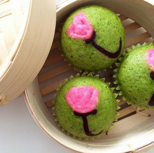 Green tea steamed cakes in a bamboo basket.