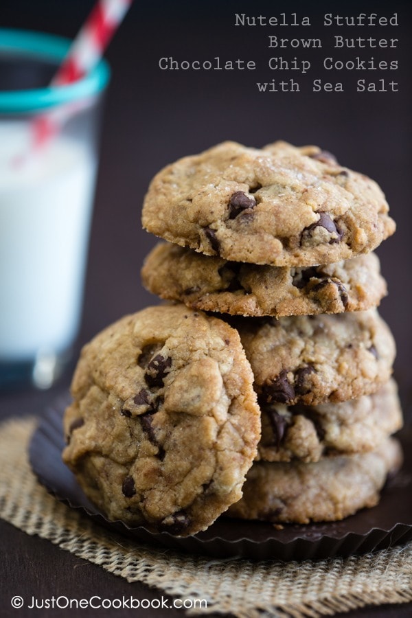 Chocolate Chip Cookies with Nutella on a plate and a glass of milk on a table.