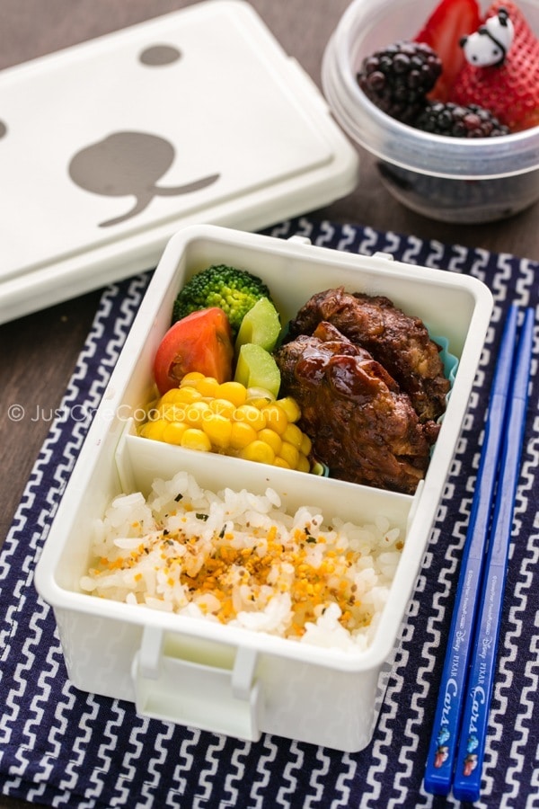 Hamburger Steak Bento with fresh fruit on a table.