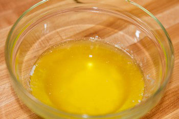 clarified butter inside a glass bowl on top of cutting board