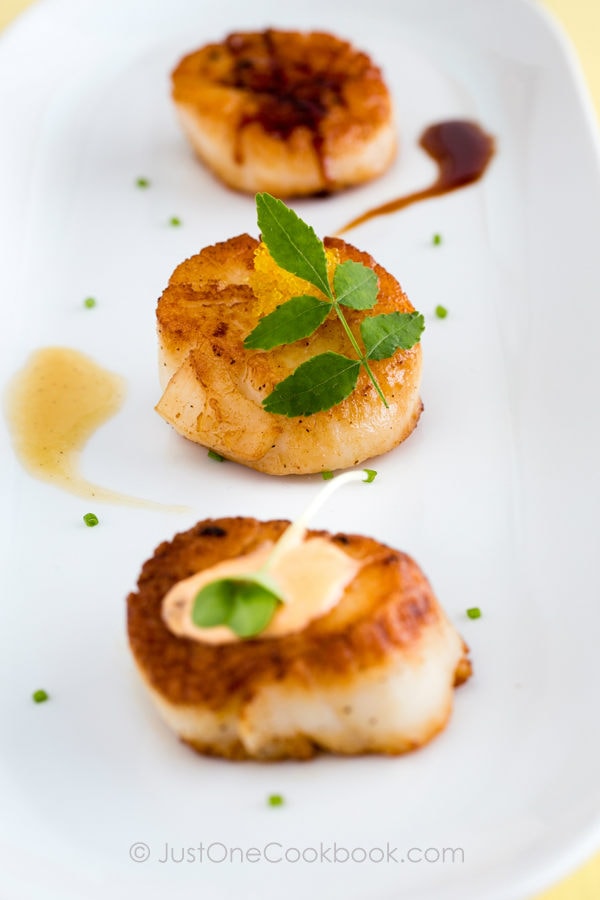 Seared Scallops with different sauces on a plate.