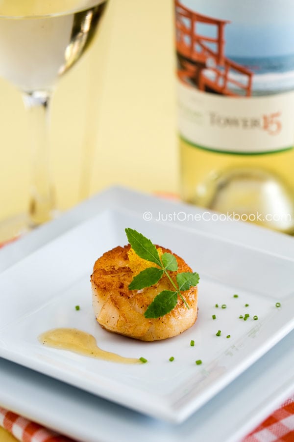 Seared Scallops | JustOneCookbook.com Seared Scallops on a white plate and a glass of wine.