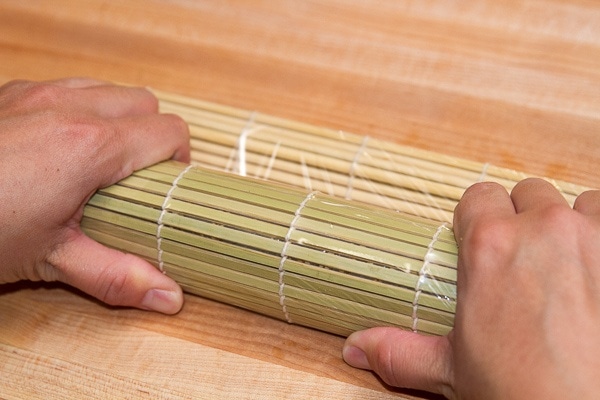 Spicy tuna rolls on a bamboo mat.