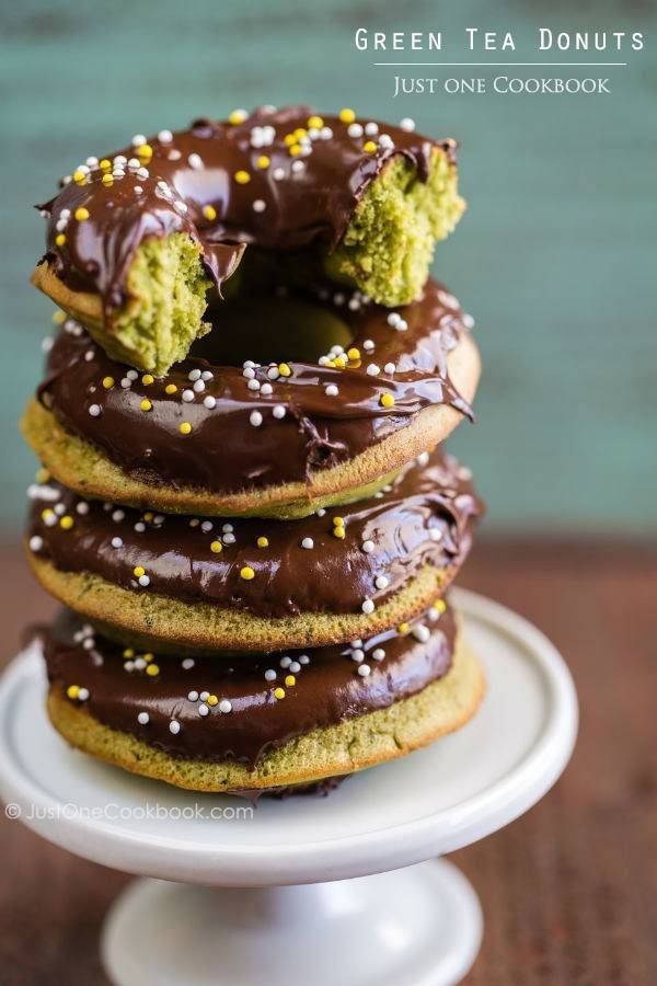 Chocolate covered Green Tea Donuts stack up on the plate.
