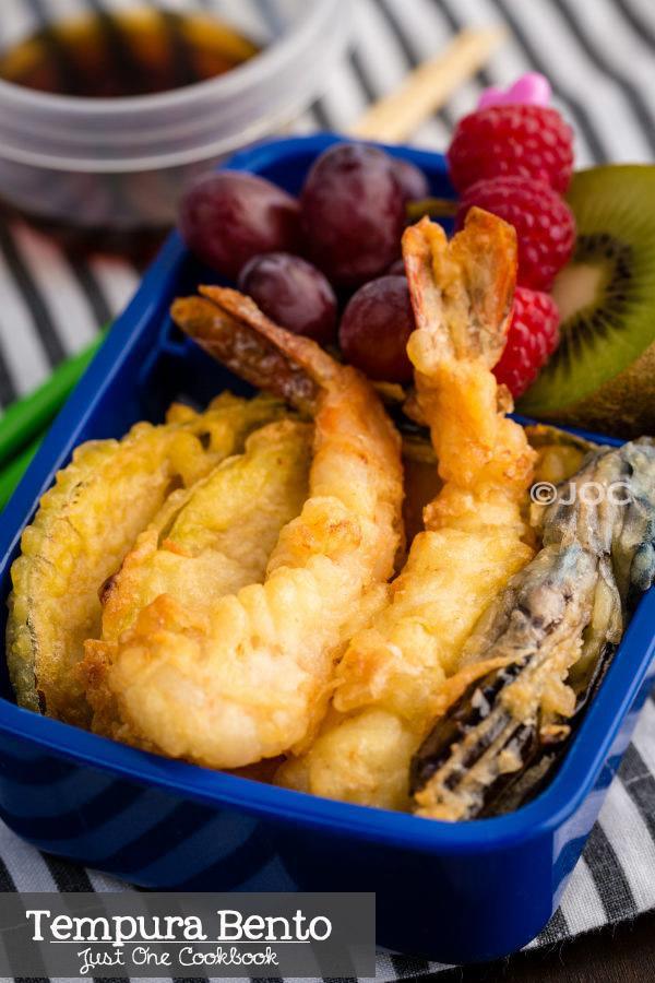 Tempura Bento with tempura, rice and fruits on a table.