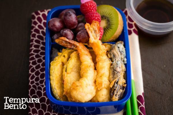 Tempura Bento with tempura, rice and fruits on a table.