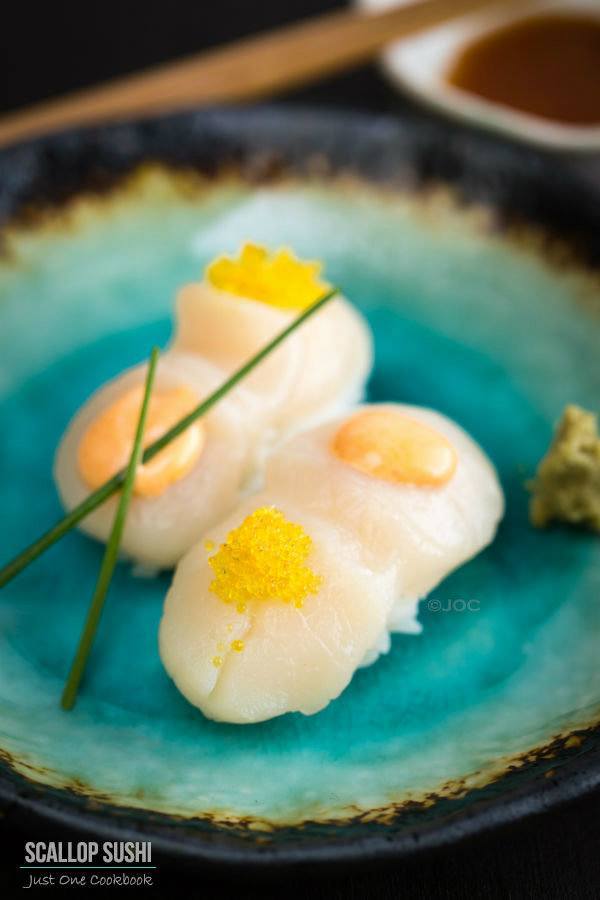 Scallop Sushi with Spicy Mayo and Yuzu Flavor Tobiko on a plate.