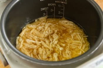 rice with seasoning and aburaage in a rice cooker pot