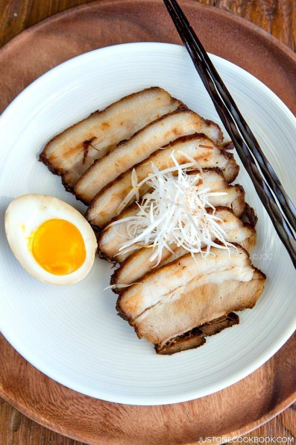 Sliced Chashu and a half ramen egg on a plate.