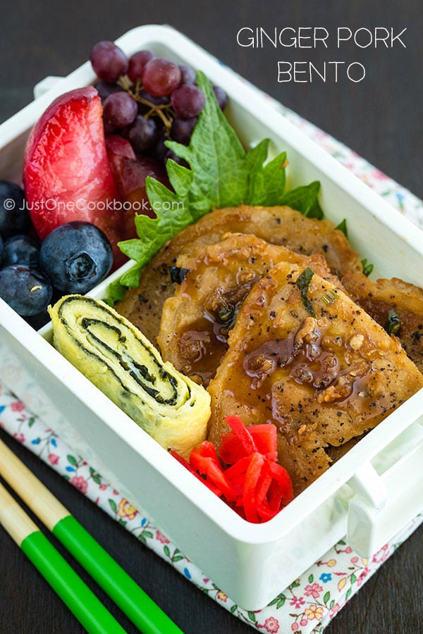 Ginger Pork Bento with fresh fruits on a table.