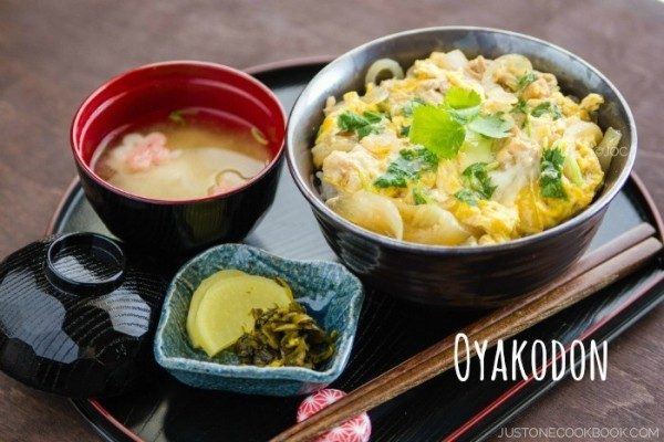 Oyakodon, pickles and miso soup on a tray.
