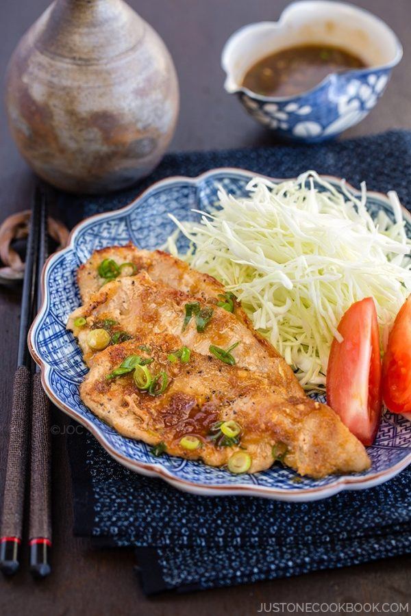 Ginger Pork with cabbage and sliced tomato on the plate.