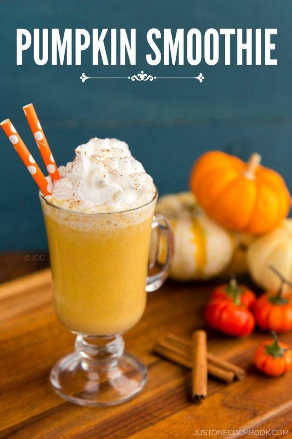 Pumpkin smoothie in a glass with whipped cream on top.