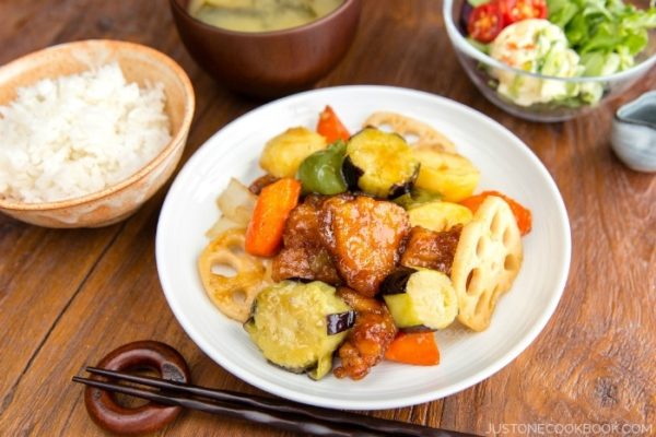 Sweet and Sour Chicken on a plate and white rice and salad.