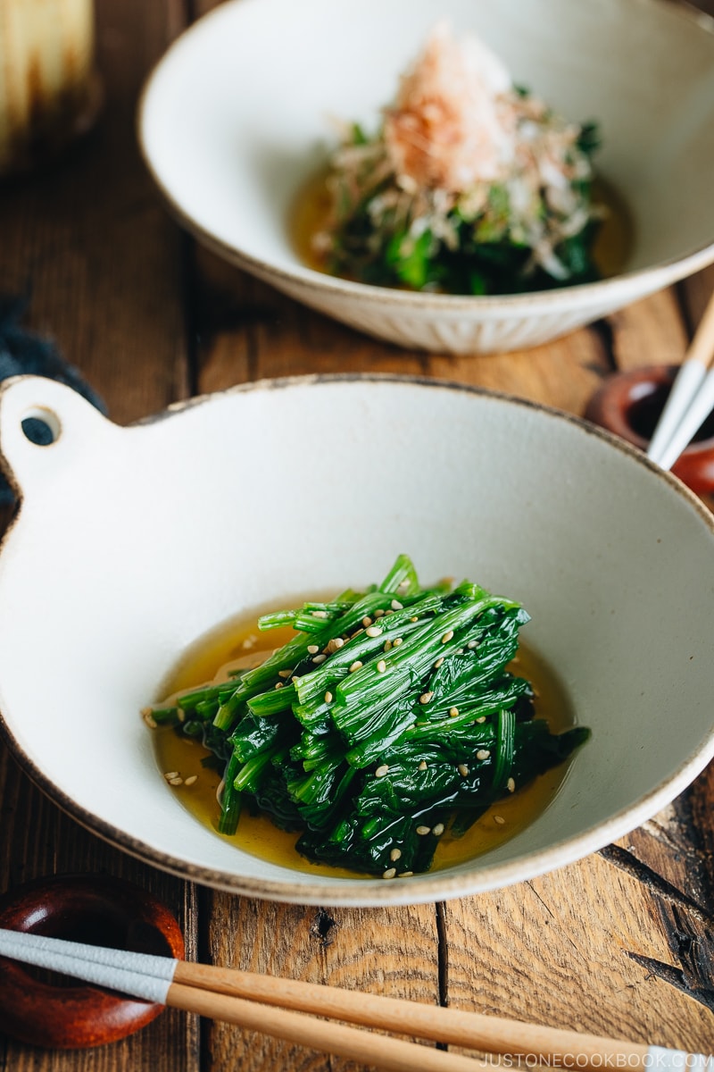 Spinach ohitashi in white ceramic plates.