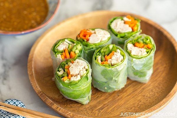 Chicken Spring Rolls on a wooden plate.