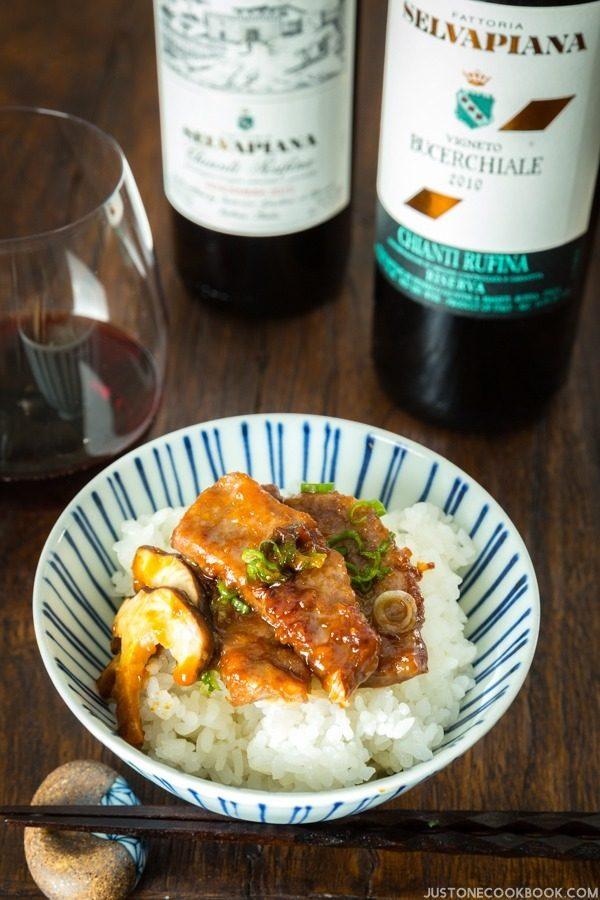 Hoba Miso with Beef over withe rice and wine on a table.