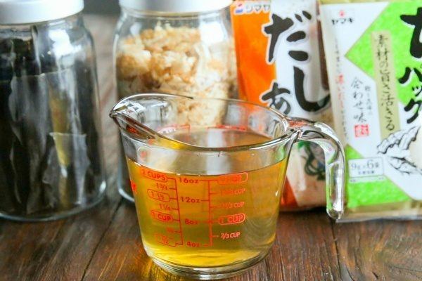 Dashi in a cup and ingredients on a table.